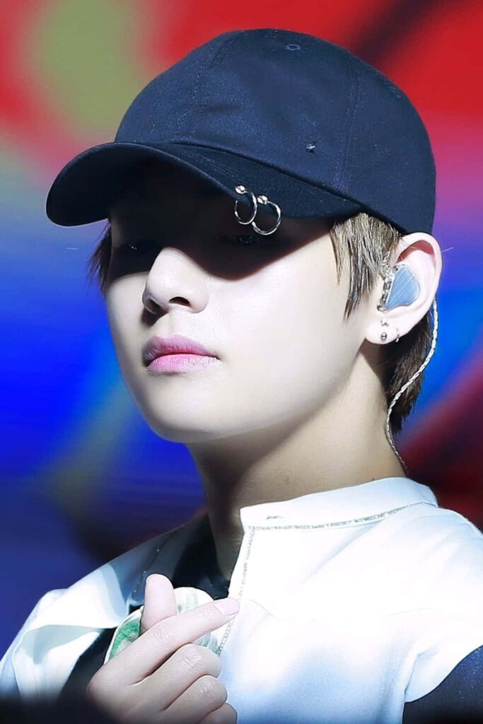 BTS V finger heart wallpaper with black cap colorful background iconic gesture image