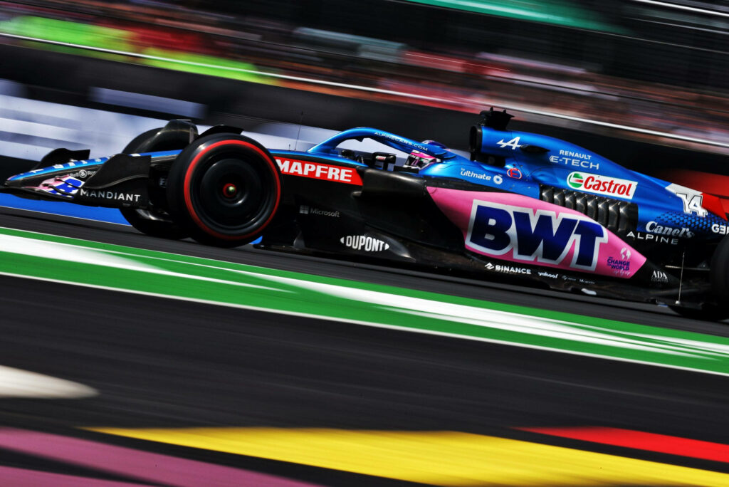 Blue and pink BWT Alpine Formula 1 car racing fast on track with vibrant livery design wallpaper