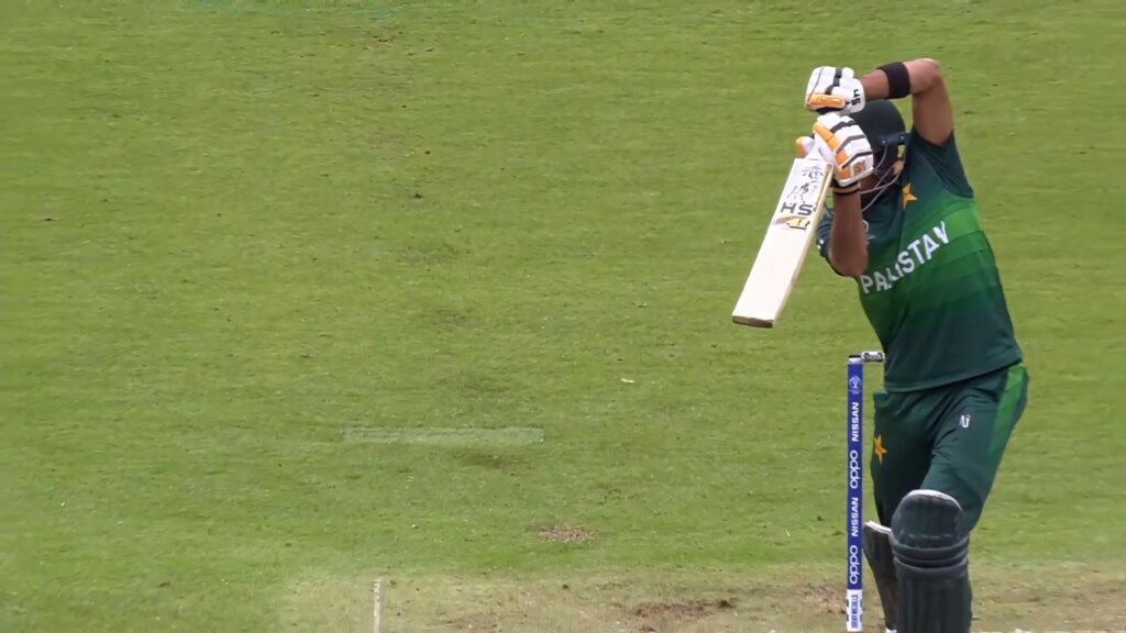 Babar Azam batting dynamically on cricket field in high energy sports action wallpaper background