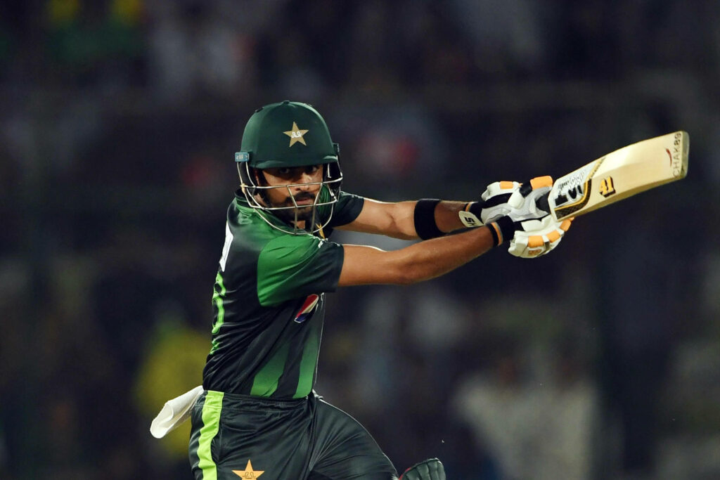 Babar Azam playing powerful cricket shot in Pakistan team uniform intense batting action wallpaper