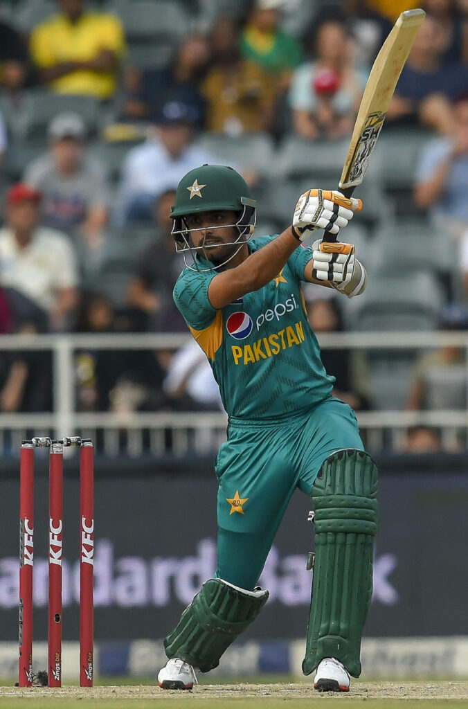 Babar Azam playing a powerful cricket shot showcasing skill and focus for Pakistan team Wallpaper