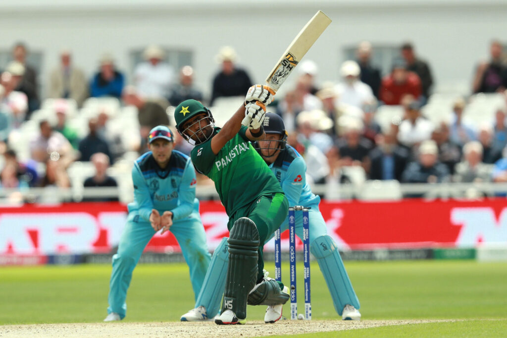 Babar Azam hitting a powerful cricket shot against England in Pakistan green jersey wallpaper
