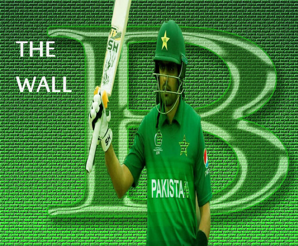 Babar Azam in Pakistan cricket jersey holding bat against green wall titled The Wall background Wallpaper