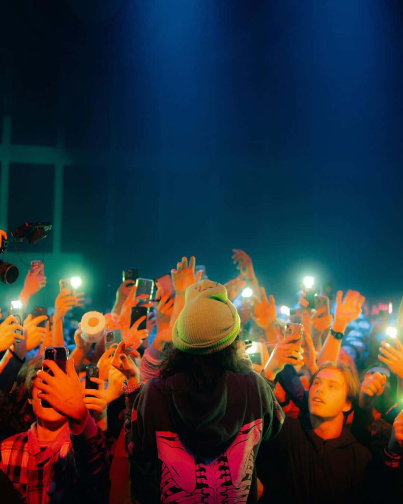 BabyTron performing live on stage with fans holding phones lighting up the vibrant concert scene Wallpaper
