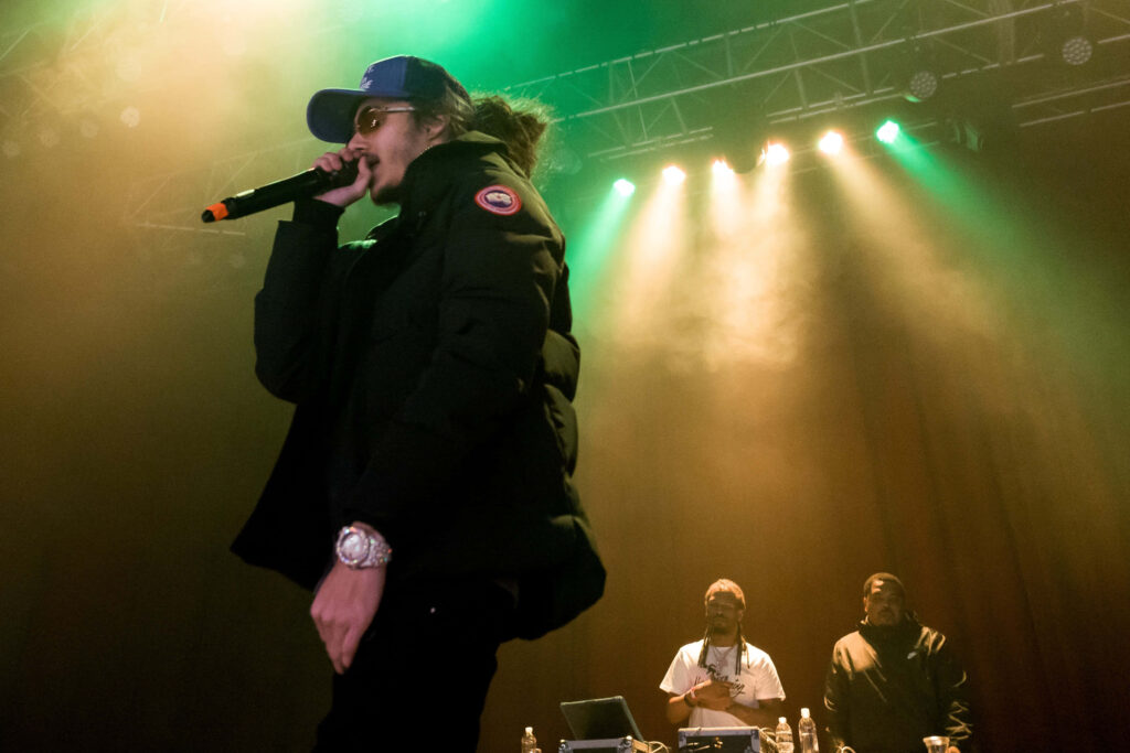 BabyTron performing live on stage vibrant lighting energetic American rapper wallpaper background