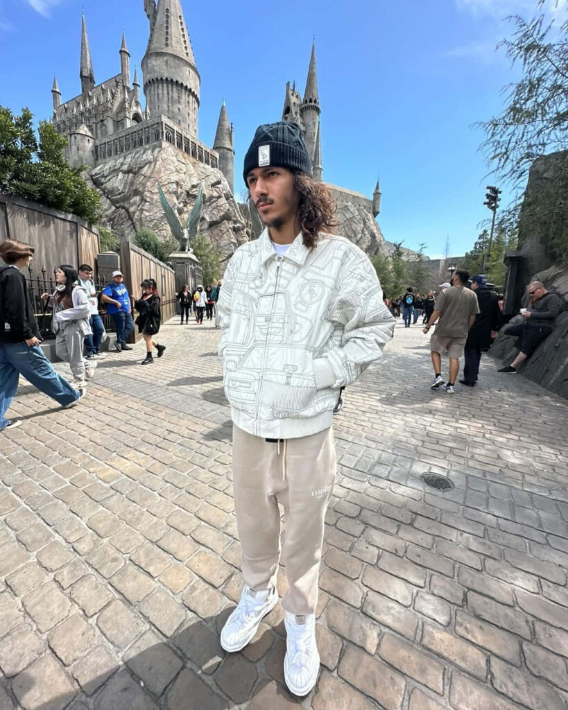 BabyTron American rapper casually posing in stylish outfit in front of amusement park castle wallpaper
