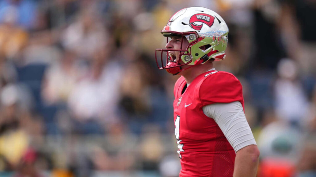 Bailey Zappe in WKU football uniform focused during an intense game moment on the field Wallpaper