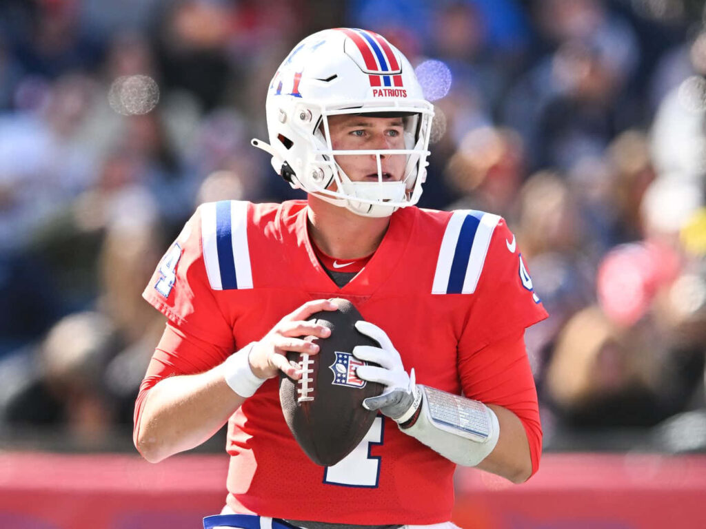 Bailey Zappe in New England Patriots uniform preparing to throw pass during NFL game wallpaper