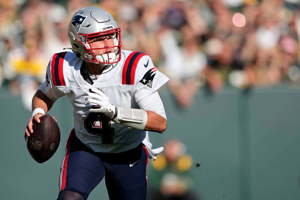 Bailey Zappe New England Patriots quarterback focused in action on football field wallpaper background