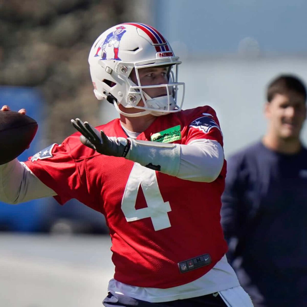 Bailey Zappe in New England Patriots practice gear throwing football focused on field action Wallpaper