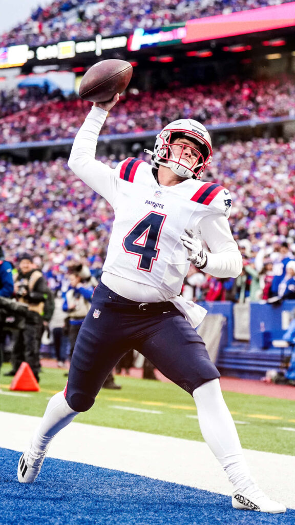 Bailey Zappe New England Patriots quarterback throws pass with focus during intense NFL game wallpaper