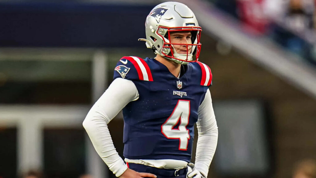 Bailey Zappe in New England Patriots uniform poised on football field dynamic wallpaper background