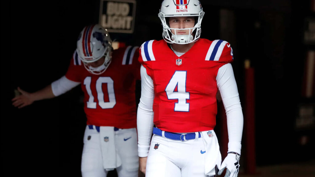 Bailey Zappe in New England Patriots uniform ready to take the field with focus and determination Wallpaper