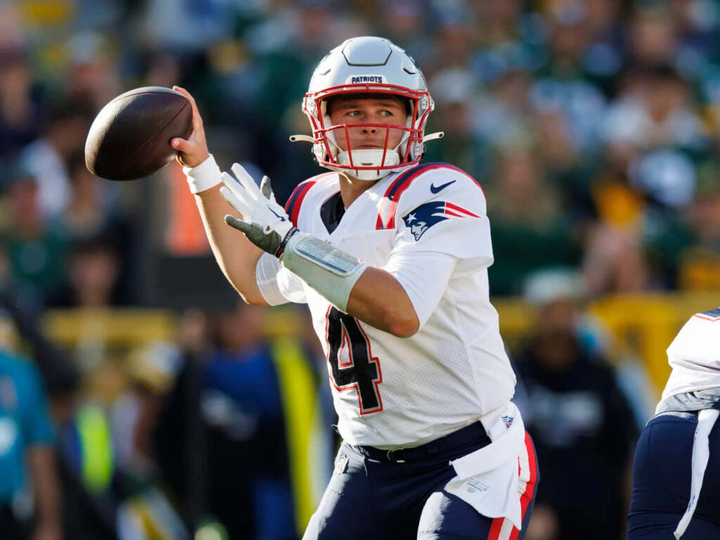 Bailey Zappe Patriots quarterback focused throwing pass during NFL game action wallpaper background