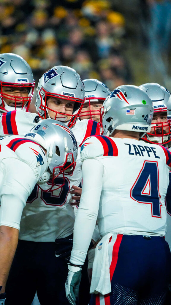Bailey Zappe leads New England Patriots teammates rallying during intense football game wallpaper