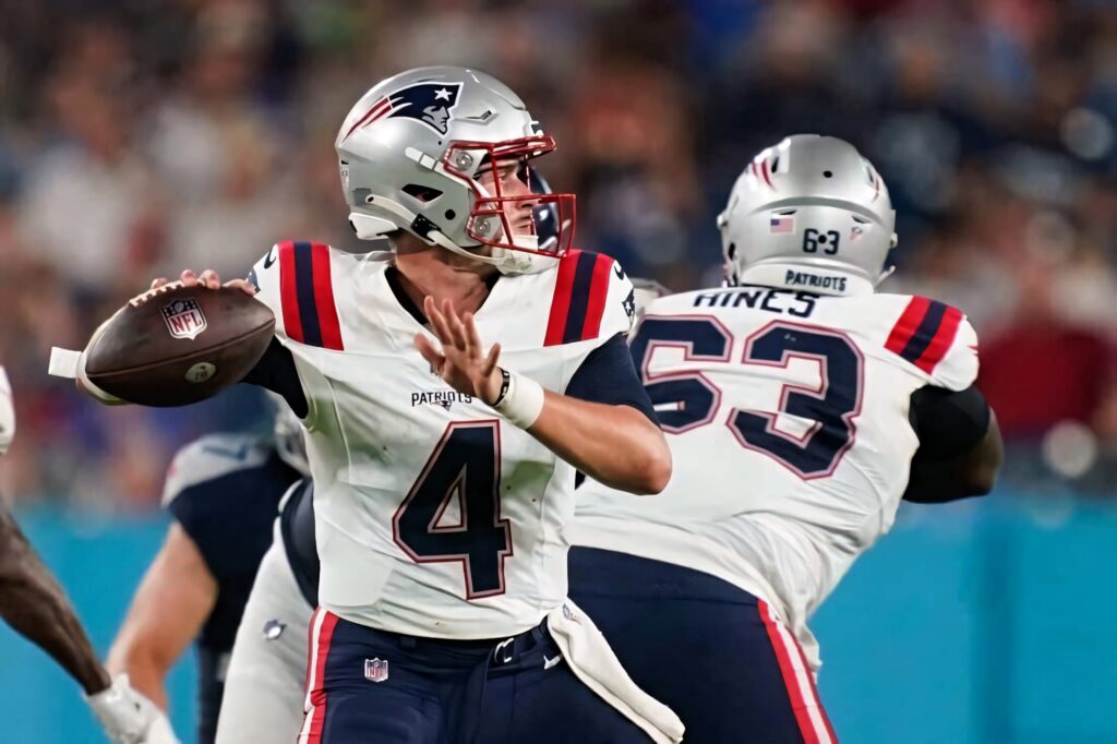 Bailey Zappe focused poised to throw pass for New England Patriots during football game wallpaper
