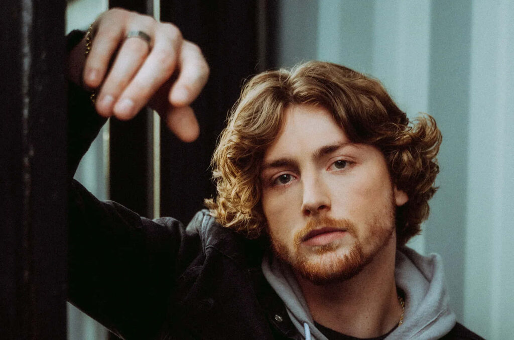 Bailey Zimmerman leaning on doorframe thoughtful moody wallpaper background for introspective mood