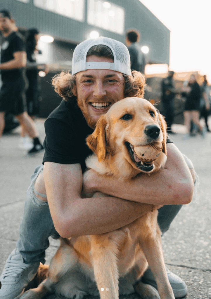 Bailey Zimmerman smiling and hugging a joyful Golden Retriever outdoors friendship wallpaper