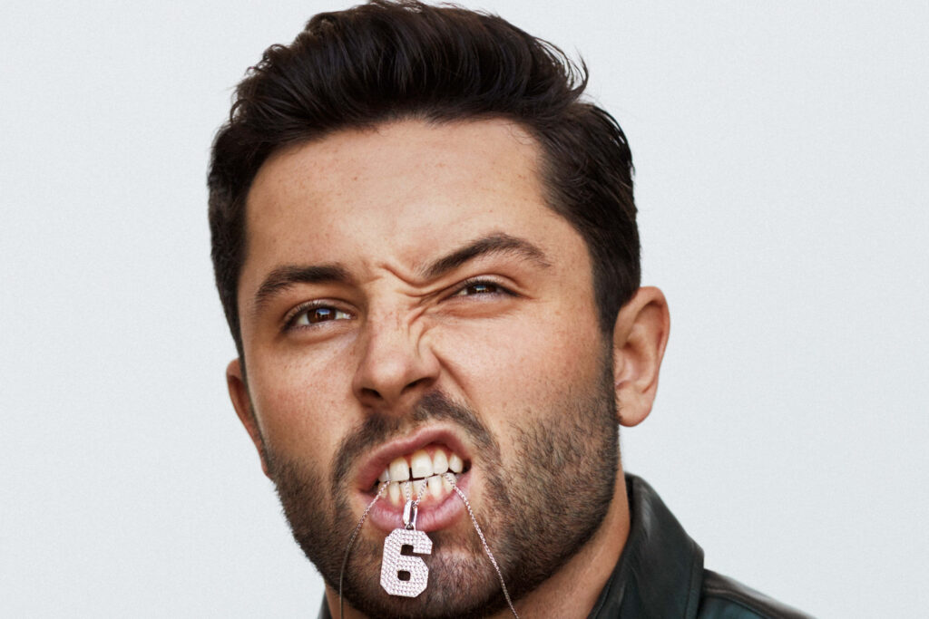 Baker Mayfield biting number 6 chain showing fierce determination and competitive spirit wallpaper