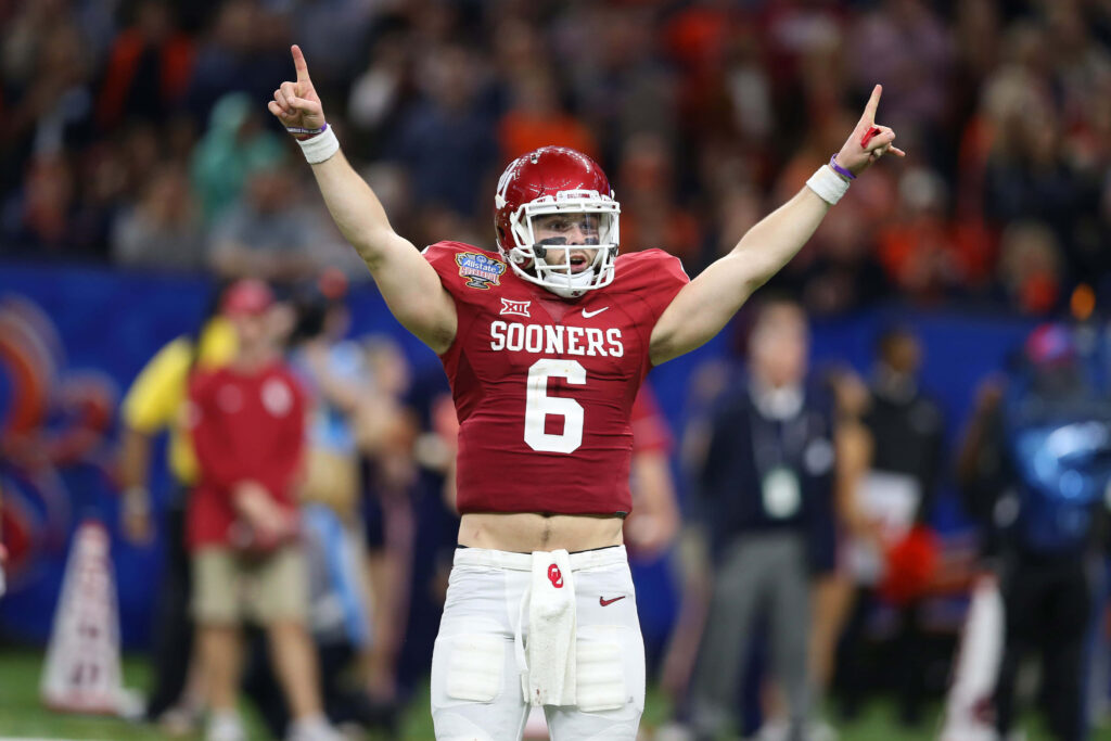 Baker Mayfield Oklahoma Sooners celebrates touchdown with arms raised on football field wallpaper