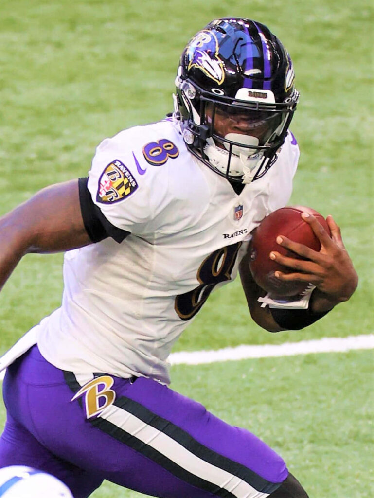 Baltimore Ravens football player running with ball intense game moment wallpaper background