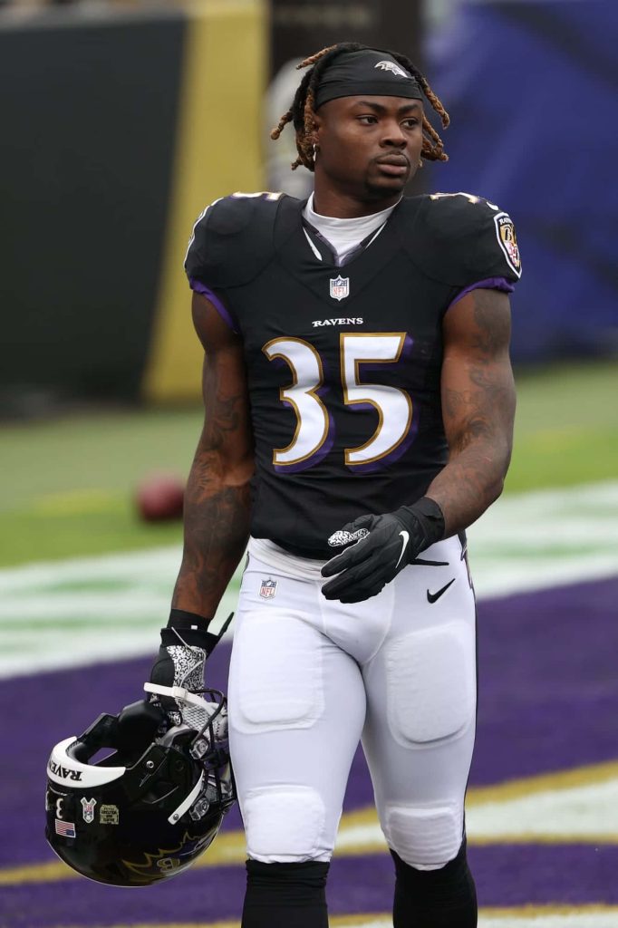 Baltimore Ravens Gus Edwards number 35 in black purple uniform with helmet on field wallpaper