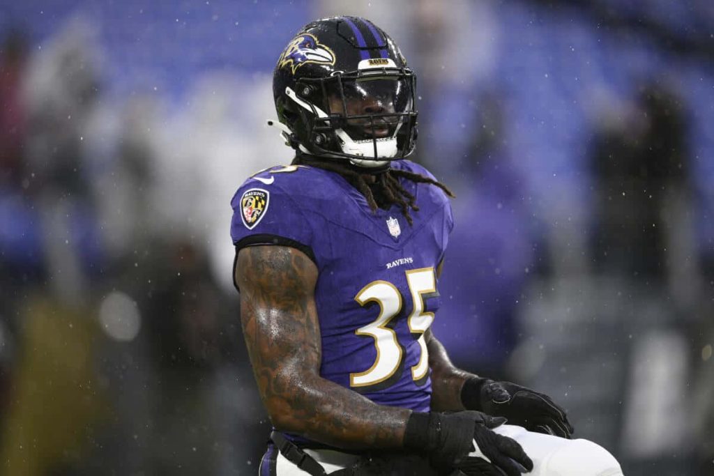 Baltimore Ravens Gus Edwards No 35 intense NFL game rain purple jersey wallpaper background