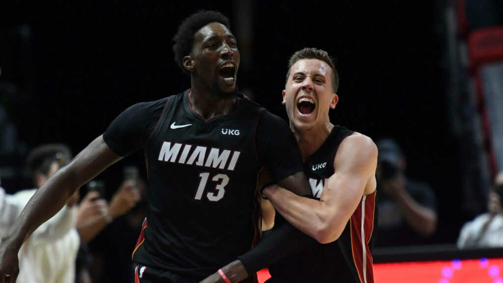 Bam Adebayo and Duncan Robinson celebrating Miami Heat victory on basketball court wallpaper background