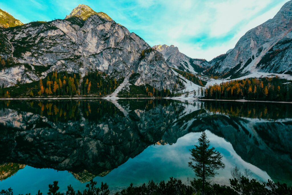 Banff National Park landscape with rugged mountains reflected in clear lake framed by vibrant trees Wallpaper