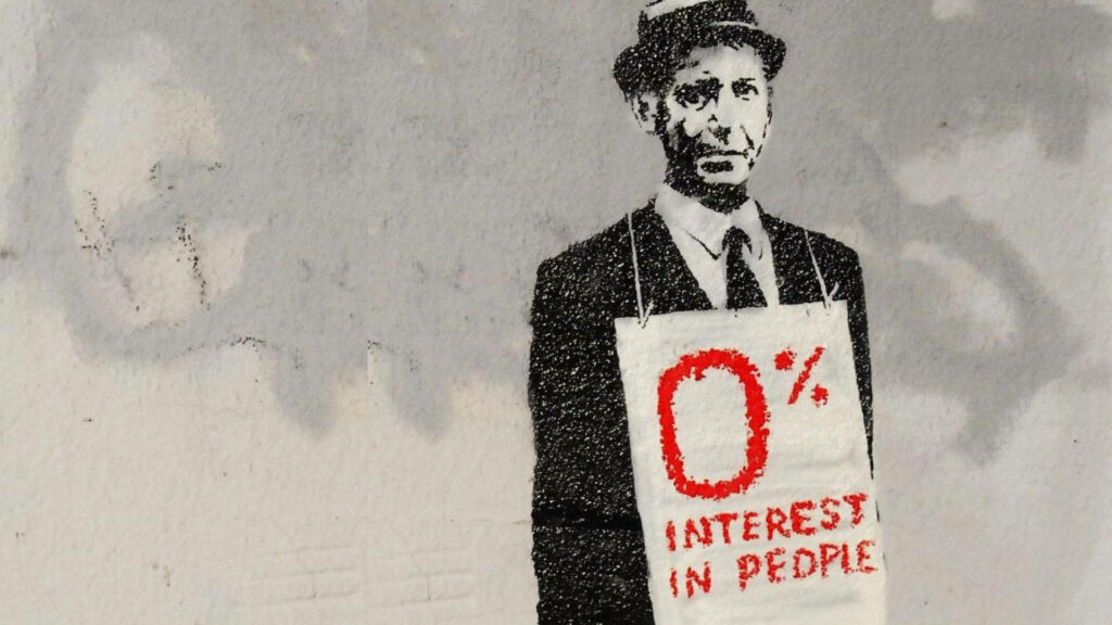 Banksy style street art of man holding 0 percent interest sign on social disconnection wallpaper