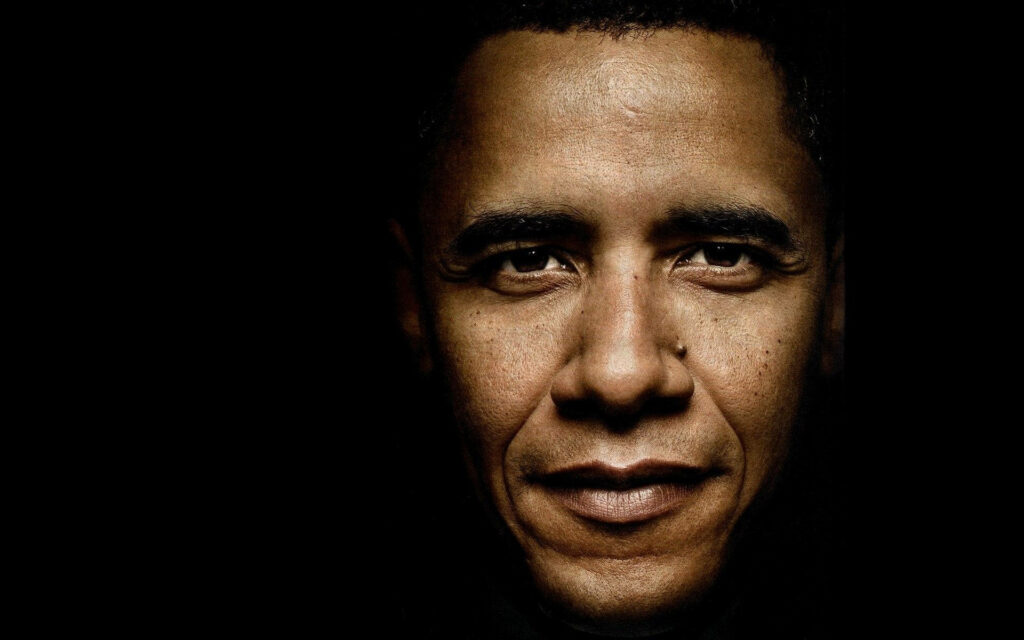 Close-up portrait of Barack Obama with thoughtful calm expression on dark background wallpaper