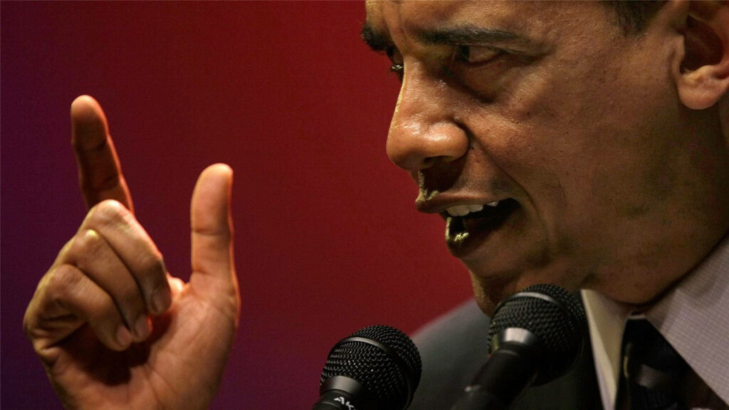 Barack Obama speaking passionately with raised finger and serious expression on red background Wallpaper