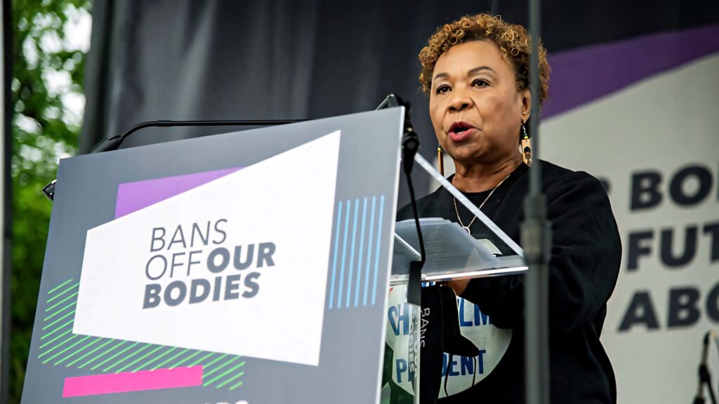 Barbara Lee speaking at reproductive rights rally behind Bans Off Our Bodies podium banner Wallpaper