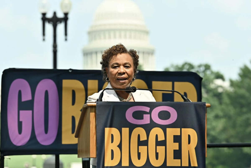Barbara Lee speaking at podium with Go Bigger banners outside United States Capitol building Wallpaper