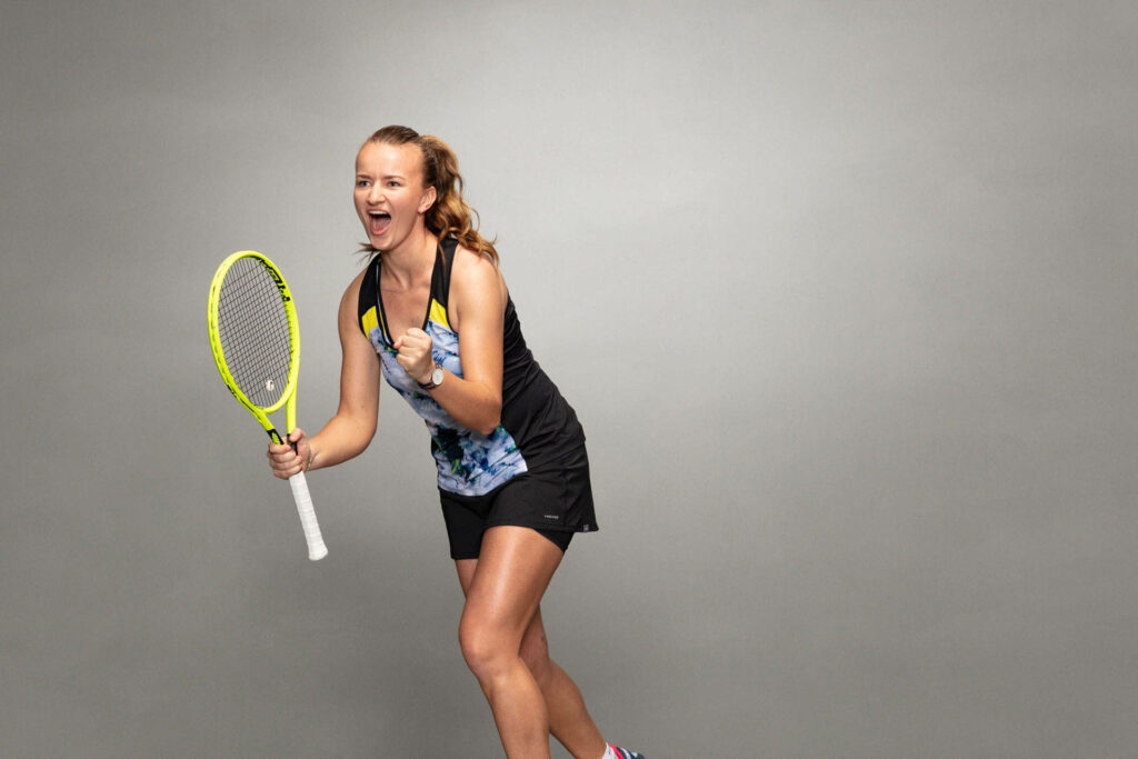 Barbora Krejčíková excited cheer with tennis racket vibrant wallpaper gray background
