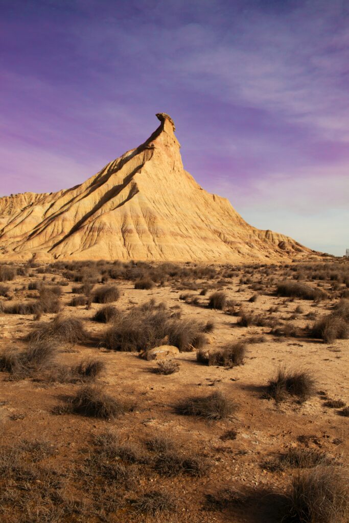 Bardenas Reales Spain desert rock formations sandstone peaks rugged terrain purple sky wallpaper