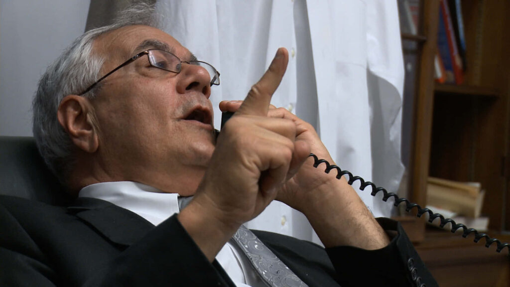 Barney Frank in office talking on phone gesturing thoughtfully wallpaper background image