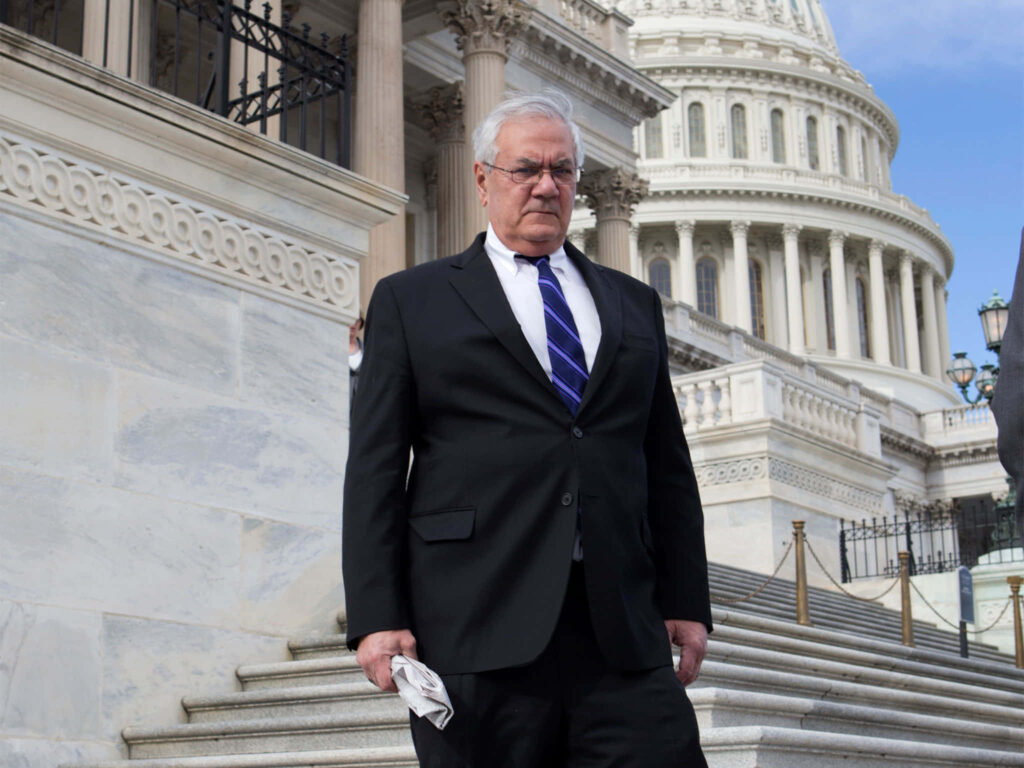 Barney Frank in suit on government building steps classic architecture background wallpaper