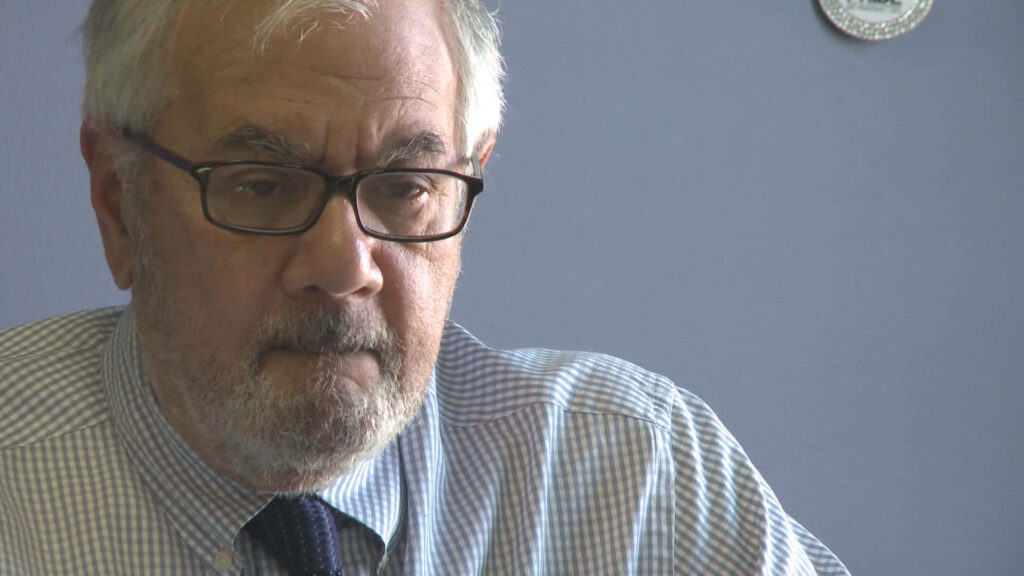 Barney Frank thoughtful portrait against soft blue background reflecting serious contemplation Wallpaper