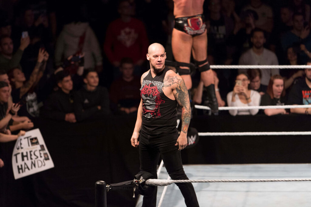 Wrestler Baron Corbin stands confidently in ring with excited crowd ready for action wallpaper