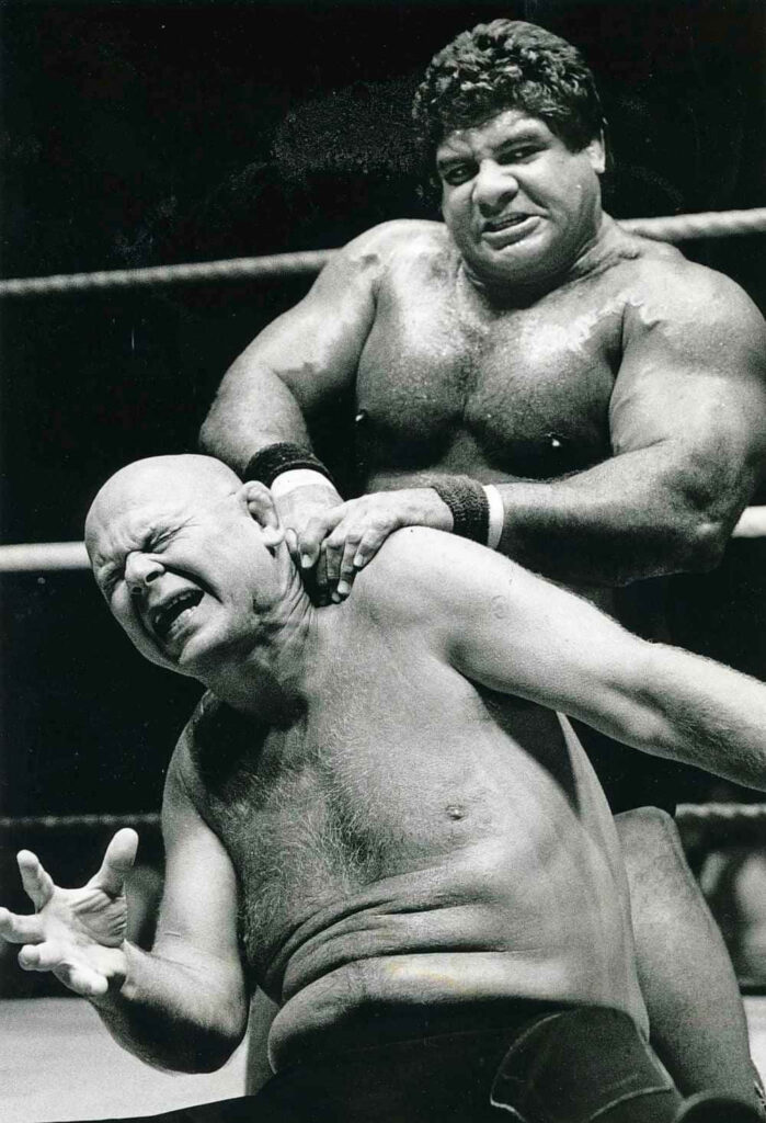 Baron Von Raschke grimaces as Don Muraco overpowers him showcasing intense wrestling action Wallpaper