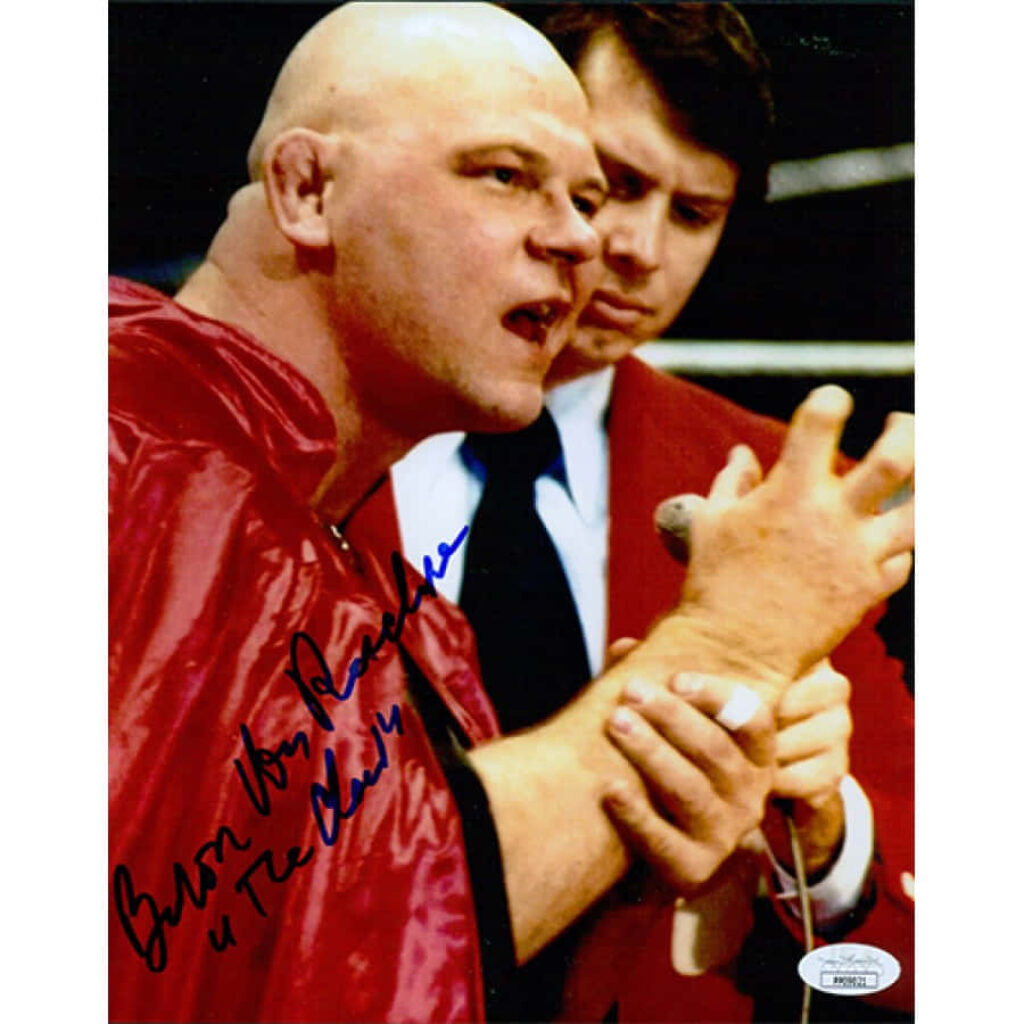 Wrestler Baron Von Raschke in cape performing claw hand pose with signed autograph wallpaper