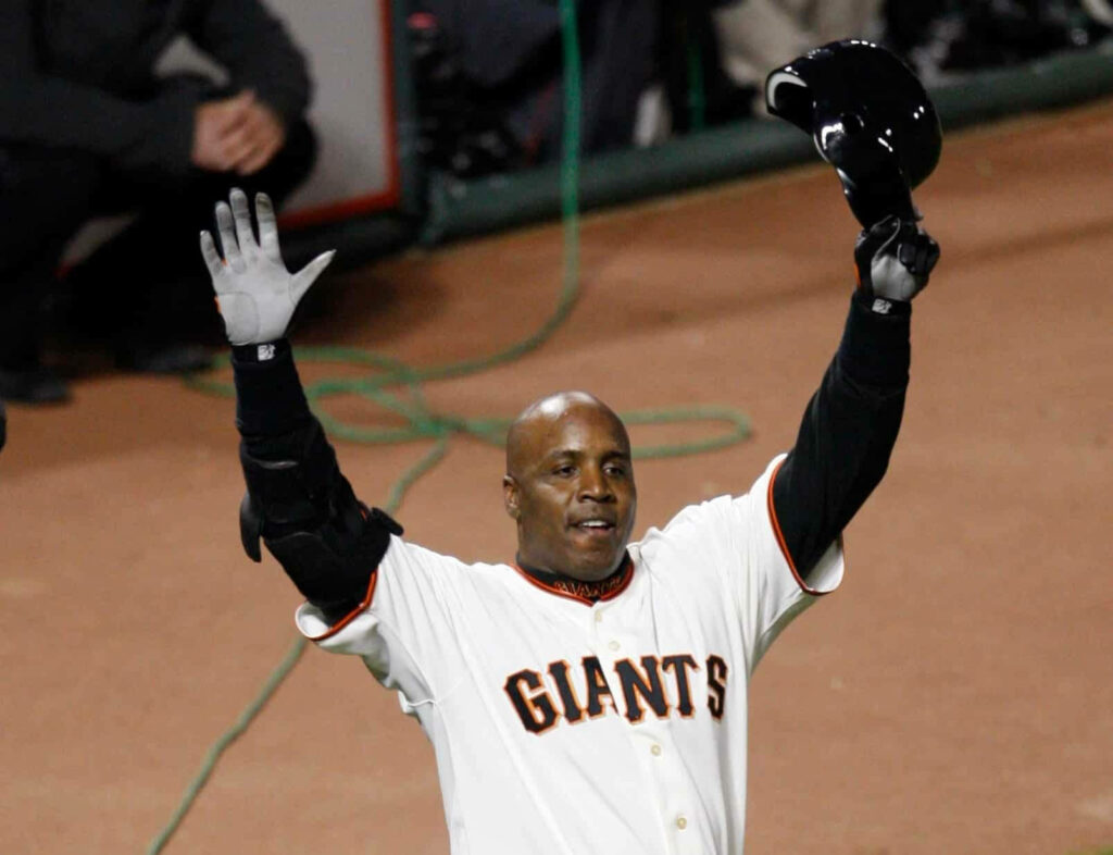 Barry Bonds celebrates in Giants uniform raising hands holding helmet on baseball field wallpaper