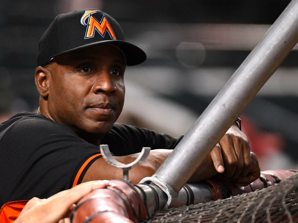 Barry Bonds focused in Miami Marlins uniform watching baseball game from dugout wallpaper background