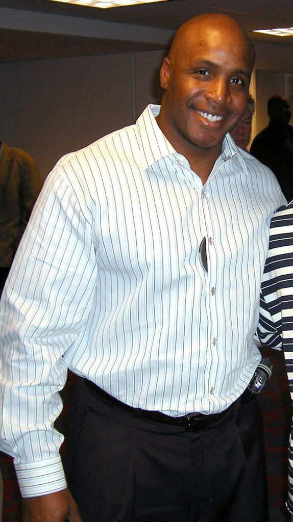 Barry Bonds smiling in striped dress shirt and dark trousers formal wallpaper background