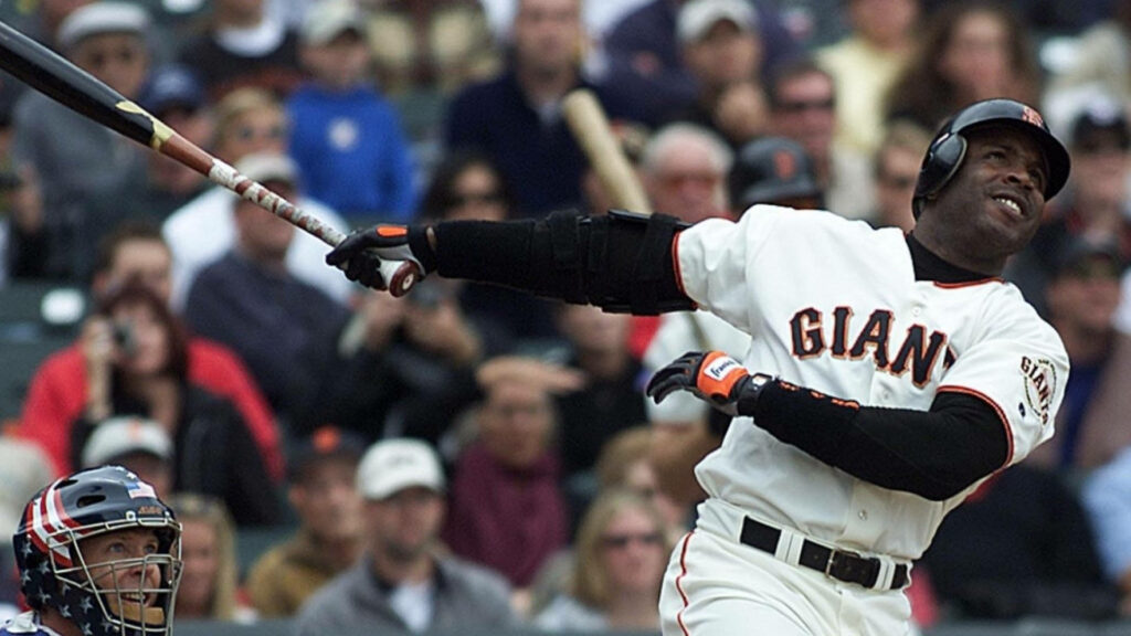 Barry Bonds smirking in San Francisco Giants uniform watching powerful baseball hit on field wallpaper