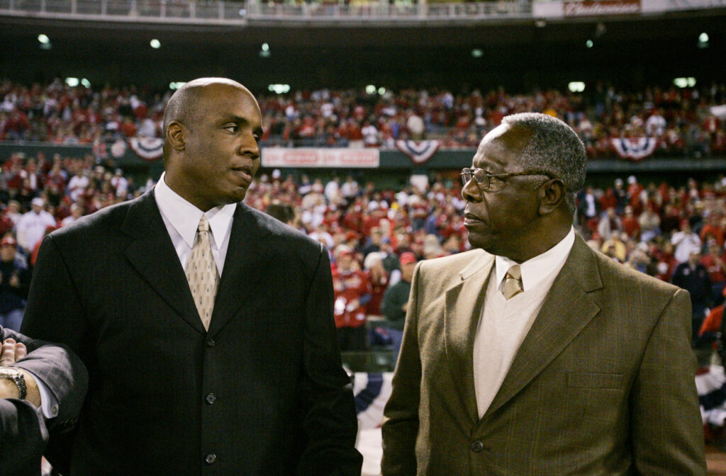 Barry Bonds and Hank Aaron in suits at stadium historic moment legendary home run hitters background Wallpaper