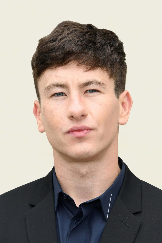 Barry Keoghan sharp in classic black suit poised portrait simple light wallpaper background