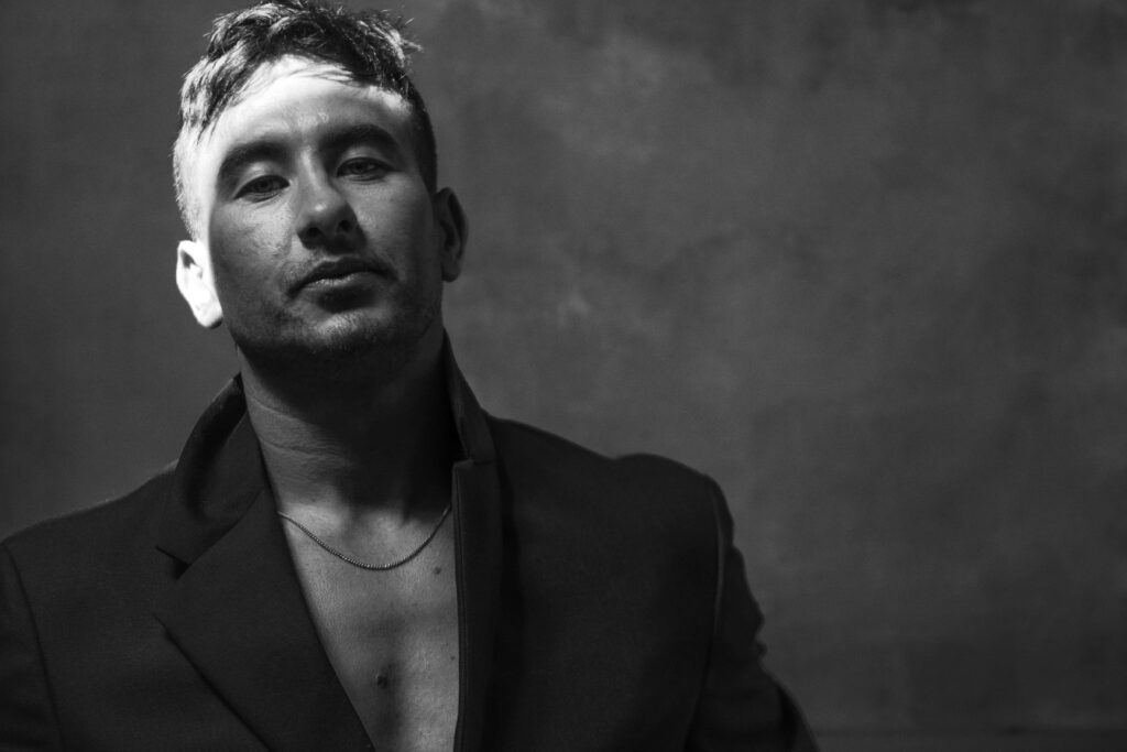 Monochrome portrait of Barry Keoghan in blazer with dramatic lighting and minimalist background Wallpaper