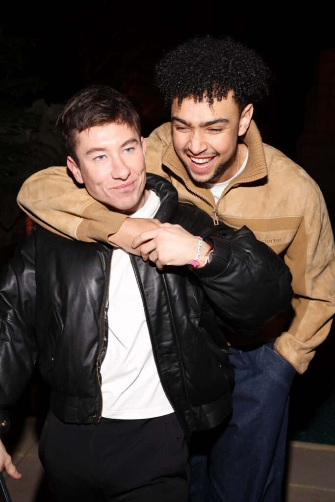 Barry Keoghan and Archie Madekwe smiling warmly in friendly nighttime embrace wallpaper background